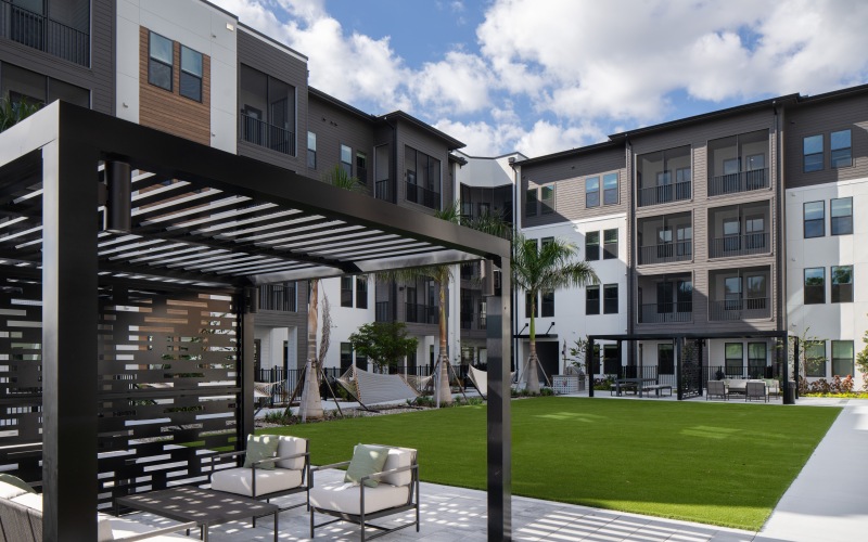 Courtyard with a pergolas and ample seating and multiple hammocks 